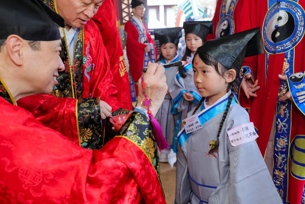圖七：黎澤森主席於麟閣內為學子以硃砂點痣於額上，寓意為孩童開啟智慧。_1
