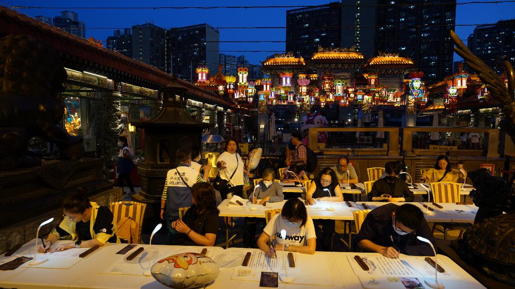 圖三. 考生在黃大仙祠大殿前抄經減壓，沉靜思緒以迎接考試。