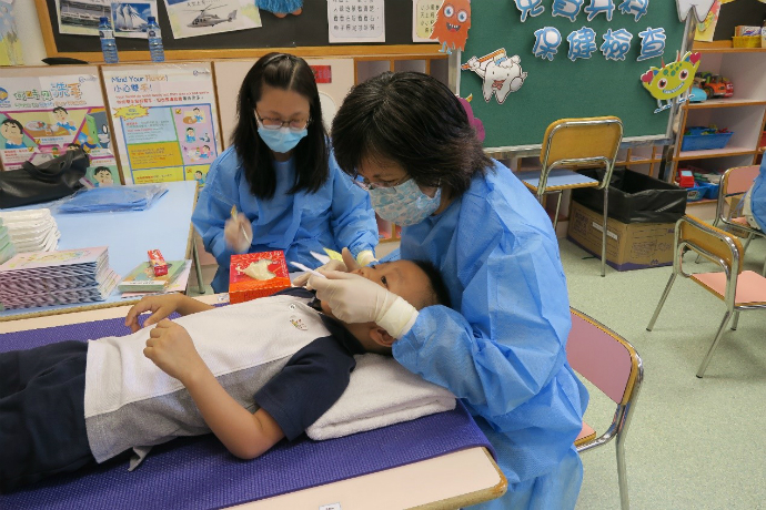 容锦明医生为小朋友检查牙齿。