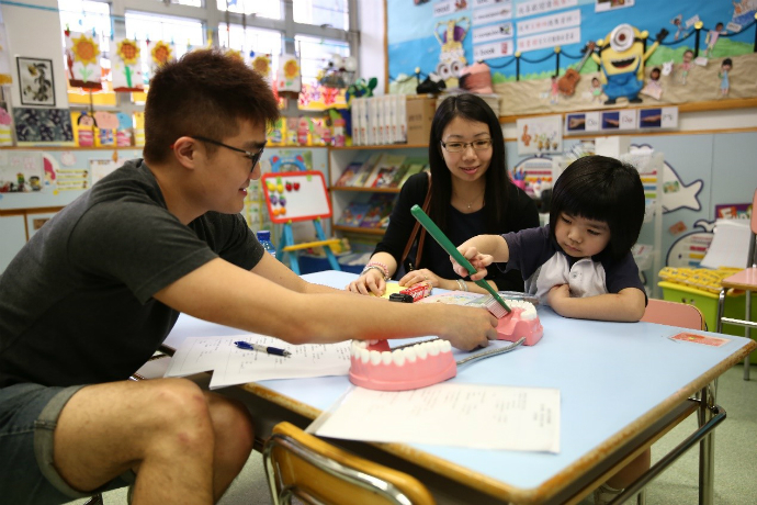 香港大学牙科学系学生义工与小朋友进行互动，教导小朋友刷牙的正确方法。